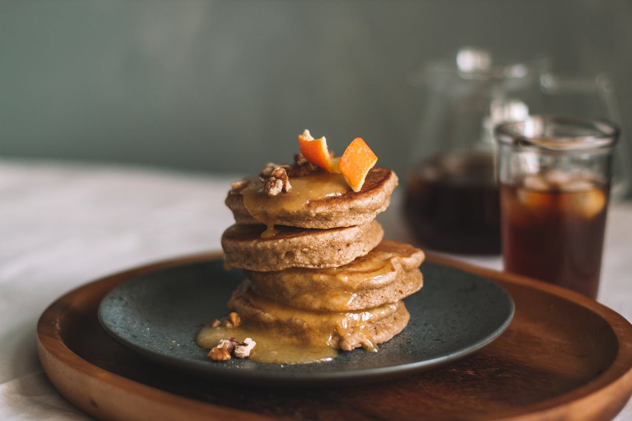 Delicious homemade pancakes served with syrup and walnuts, perfect for a cozy breakfast.