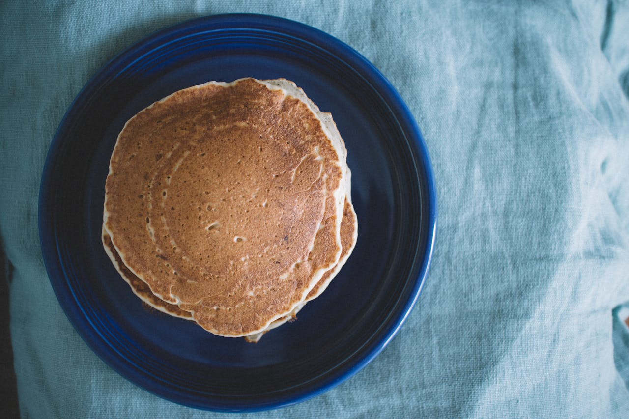 Mastering the First Impression: Your intriguing post title goes here Aerial view of homemade pancakes on a blue plate, ready for breakfast.
